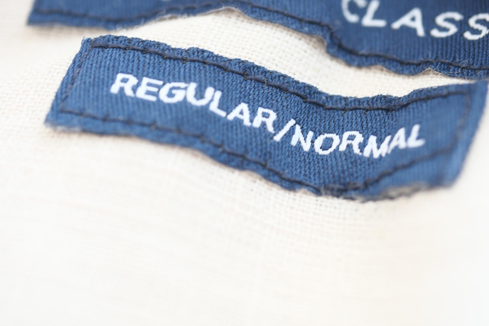 Embroidered textile label with compliance tag